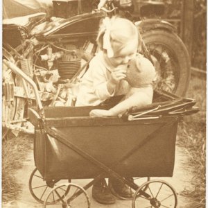 Kind mit Bär im Kinderwagen