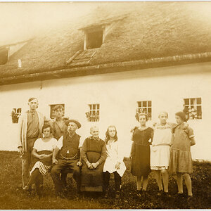 Familienporträt vor Bauernhaus mit Strohdach