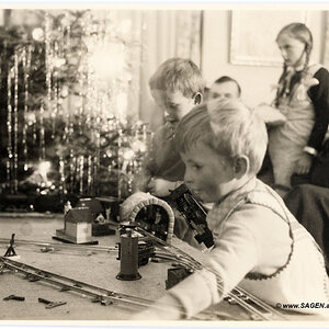 glückliche Kinder mit Modelleisenbahn unter dem Christbaum