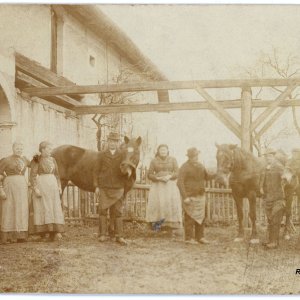 Bauernfamilie mit ihren Pferden vor dem Bauernhof