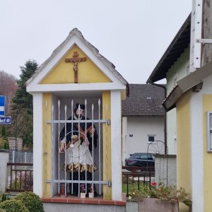 Marterl neben einem Holz-Glockenturm