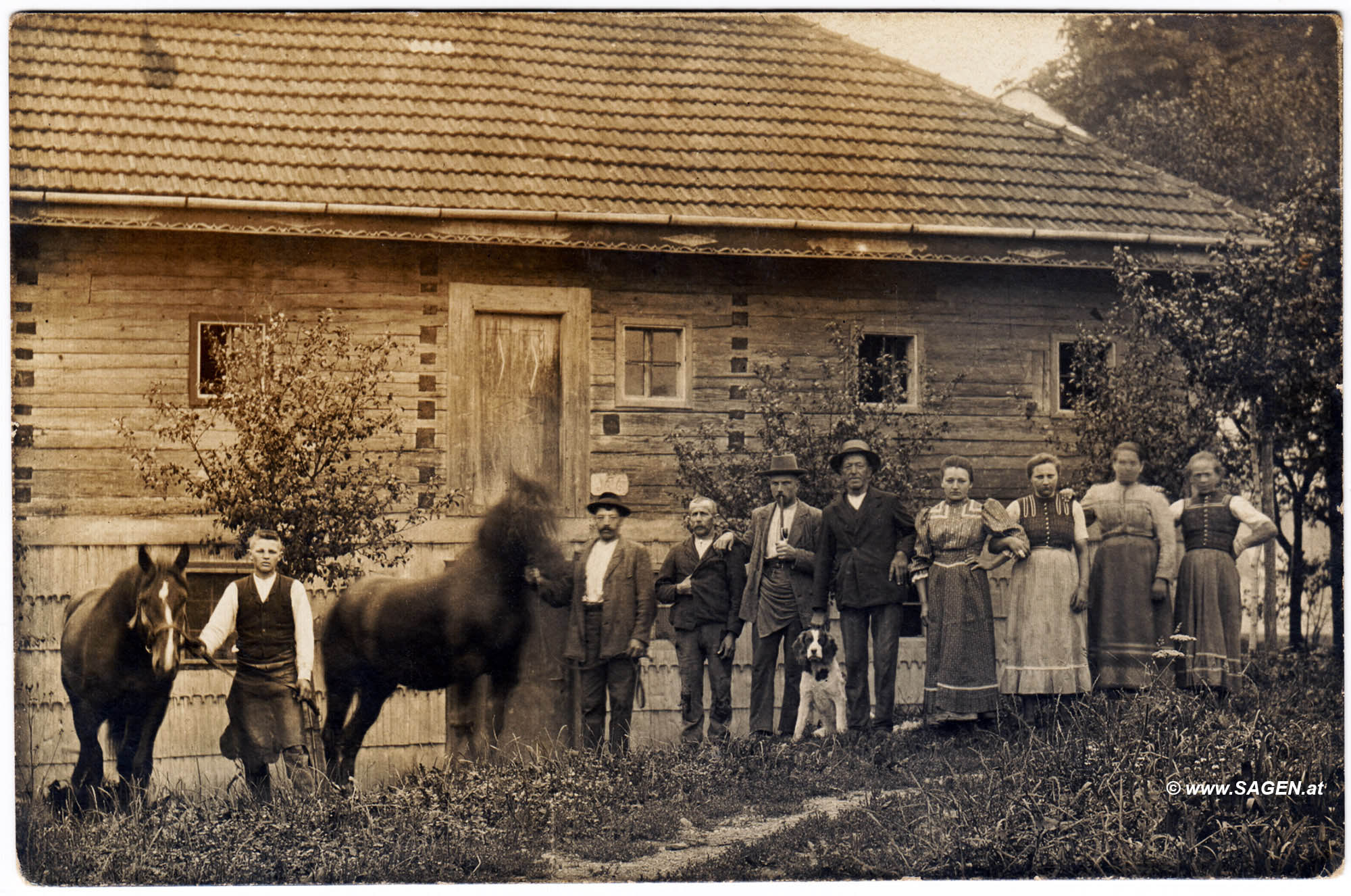 Bauernfamilie vor hölzernem Bauernhaus