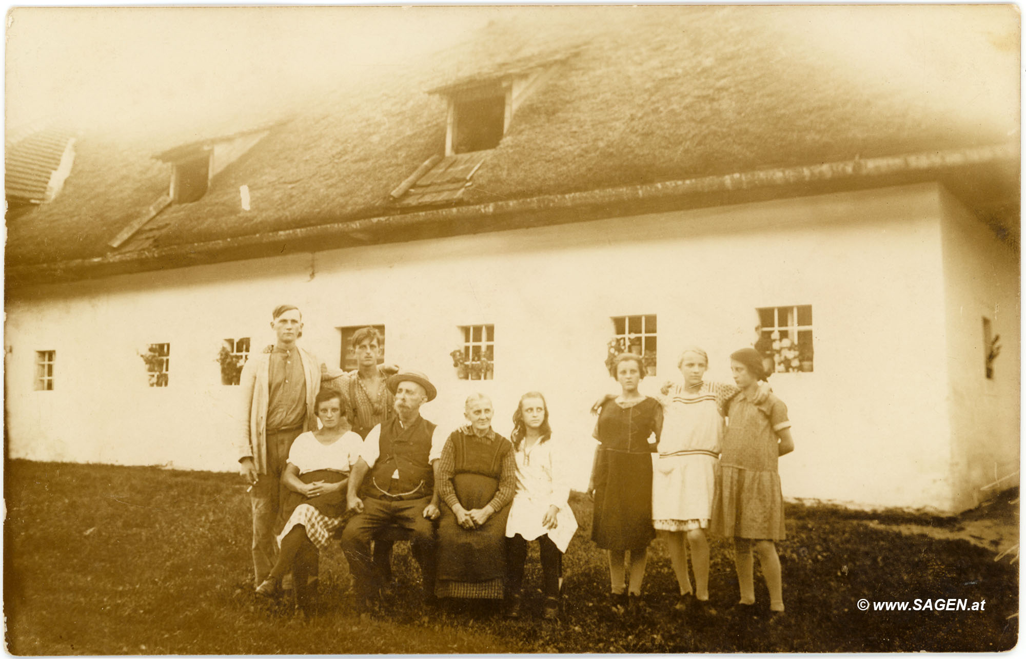 Familienporträt vor Bauernhaus mit Strohdach