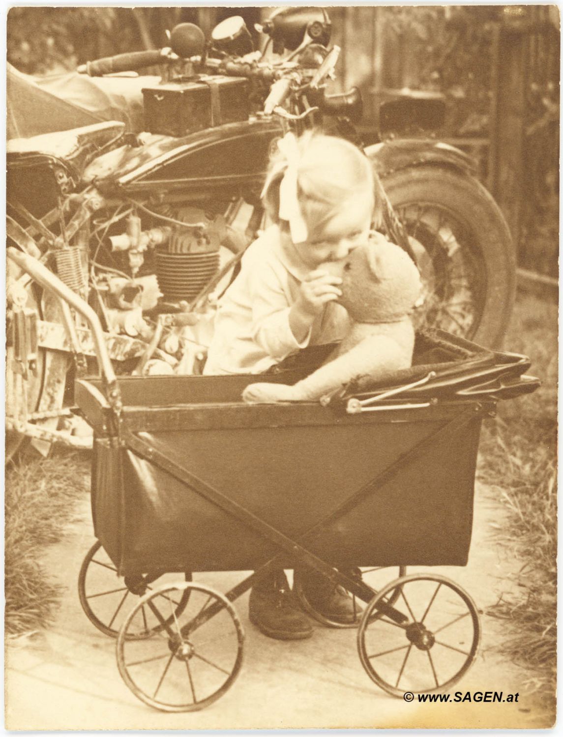 Kind mit Bär im Kinderwagen